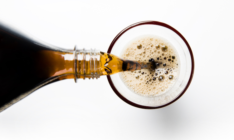 A glass of cola being poured into a glass