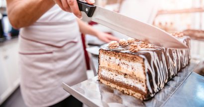 Pastry chef taking slice of