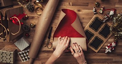 Woman wrapping christmas gifts overhead