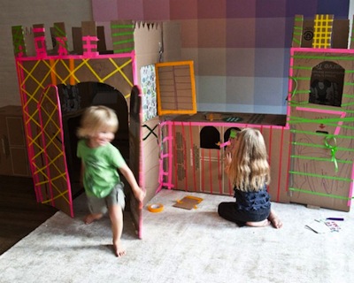 Kids play around cardboard castle