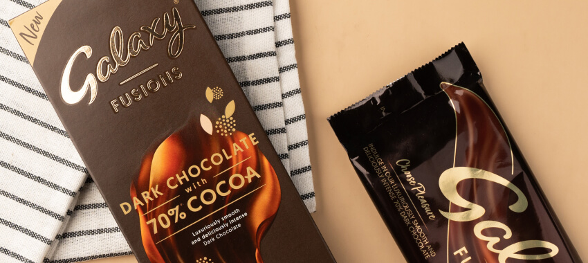 Galaxy Fusions premium dark chocolate bar packaging with bronze foil design on striped kitchen towel