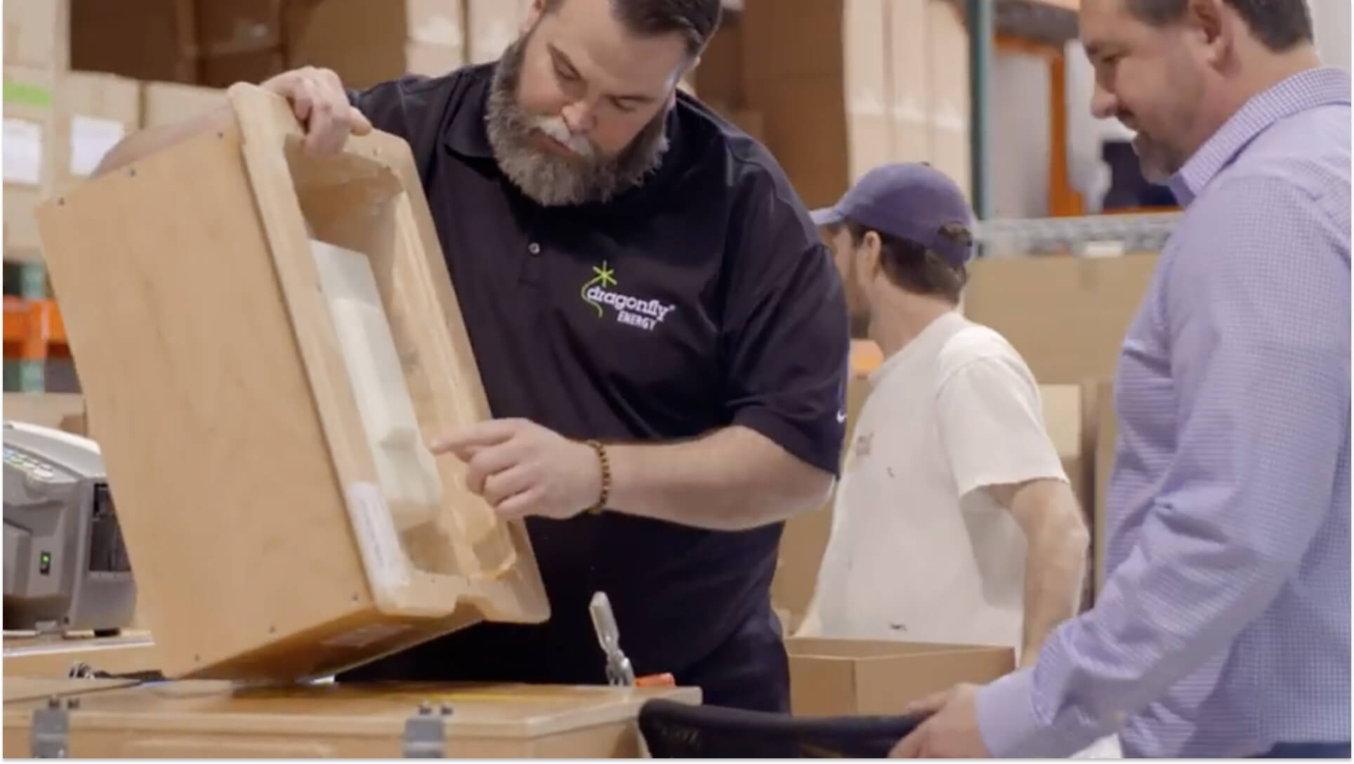 Packaging specialist demonstrating molded fiber container design to clients in manufacturing facility