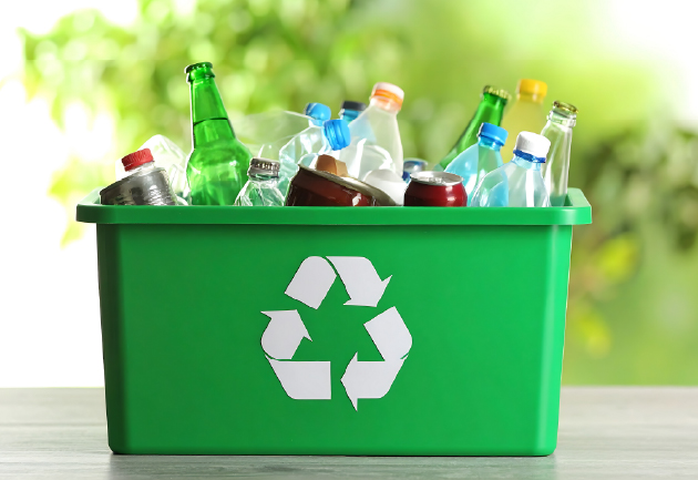 A green recycling bin filled with various bottles and containers, representing the traditional approach to dealing with packaging waste.