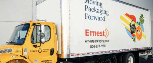 Yellow Ernest Packaging Solutions delivery truck with branded white trailer displaying company logo and contact information