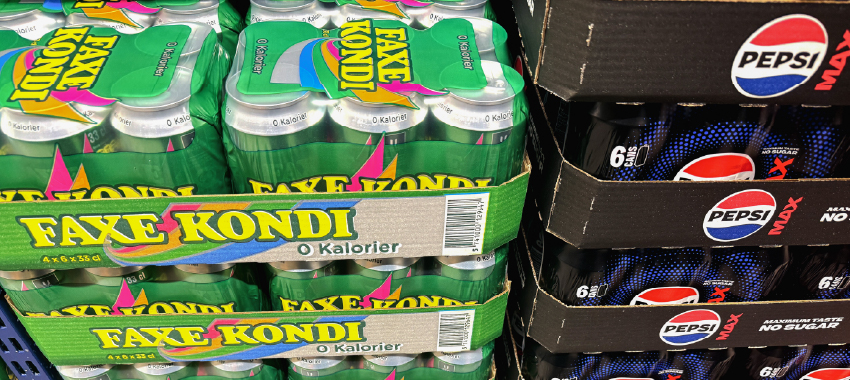 Stacked multipacks of Faxe Kondi and Pepsi Max cans on store shelves, showing branded secondary packaging layers.