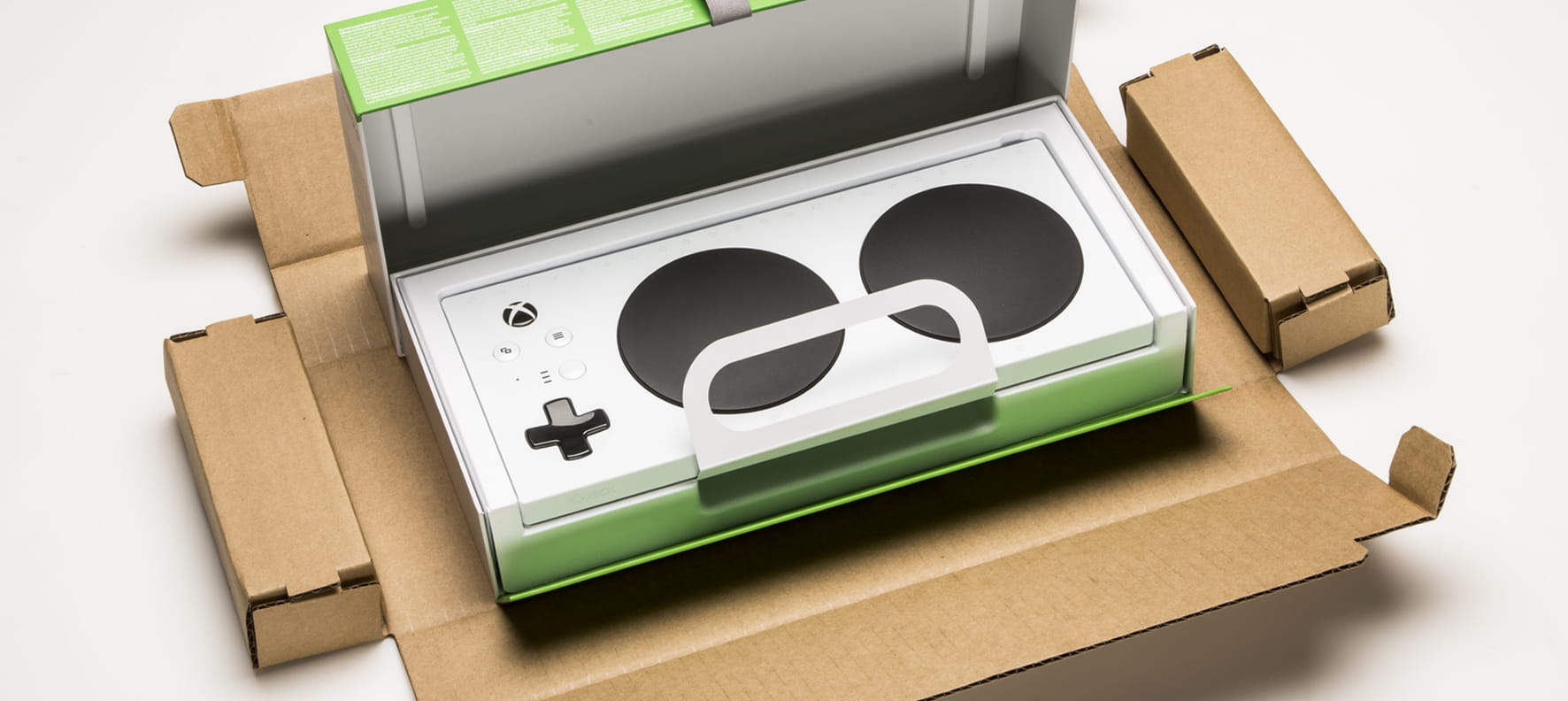 Microsoft Xbox Adaptive Controller displayed in open accessible packaging designed for one-handed unboxing.