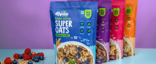Four colorful Alpino Health Foods Super Oats pouches in blue, purple, pink, and orange, displayed with berries.