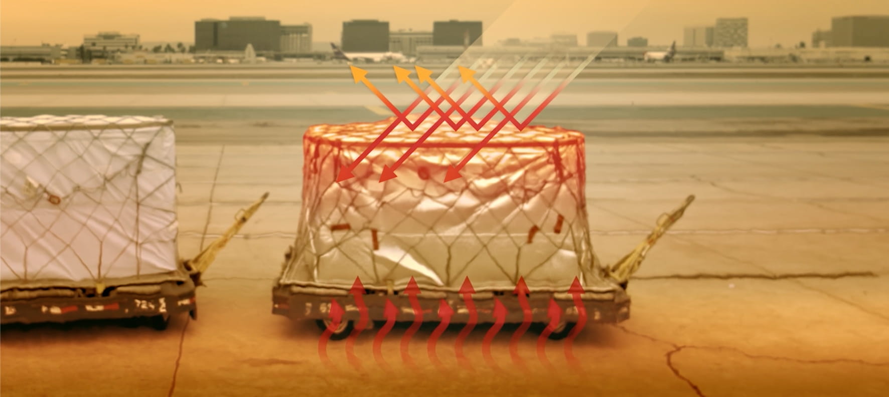 Diagram showing heat radiation arrows striking a shrink-wrapped air freight pallet on an airport tarmac.