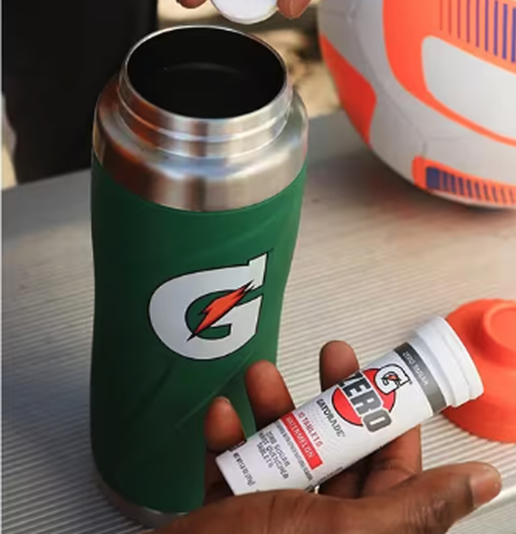 Reusable green Gatorade bottle with man’s hand holding Gatorade tablets